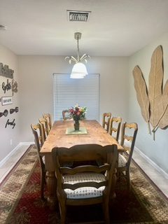 A dining room table with chairs and a mirror