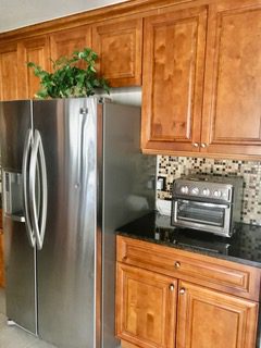 A kitchen with stainless steel appliances and wooden cabinets.